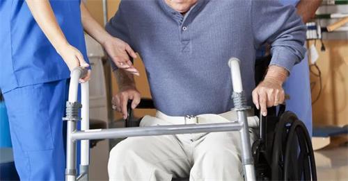 北京京通医院康复科医护人员协助患者进行转移及步行训练